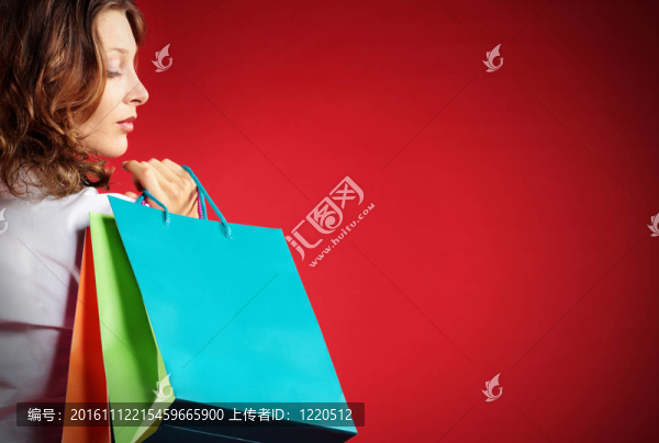 拿著紅色背景的購物袋的女人