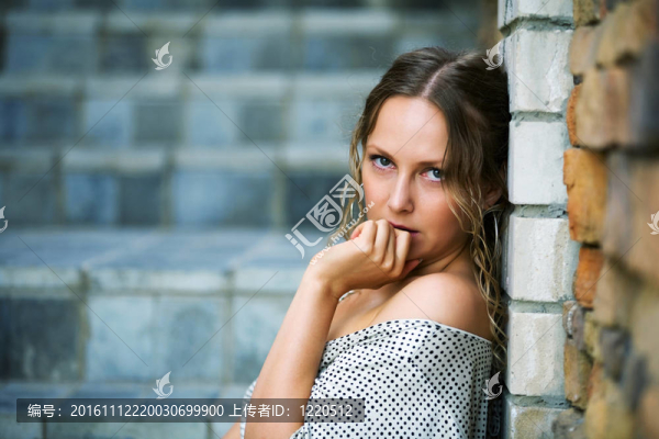 傷心的女人靠著一塊石頭墻