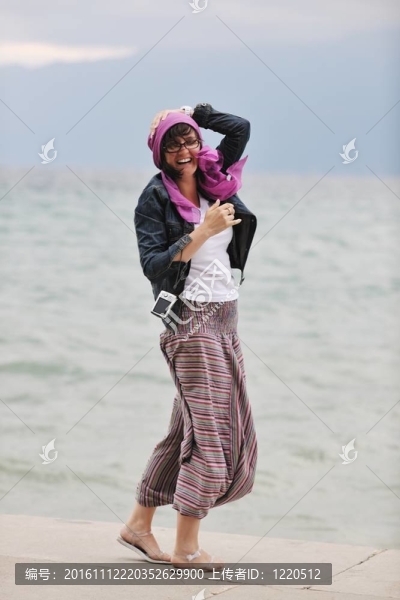 美麗的年輕女子在海灘與圍巾