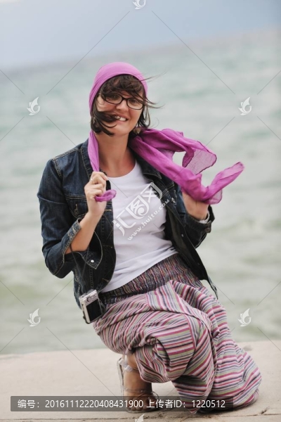 美麗的年輕女子在海灘與圍巾