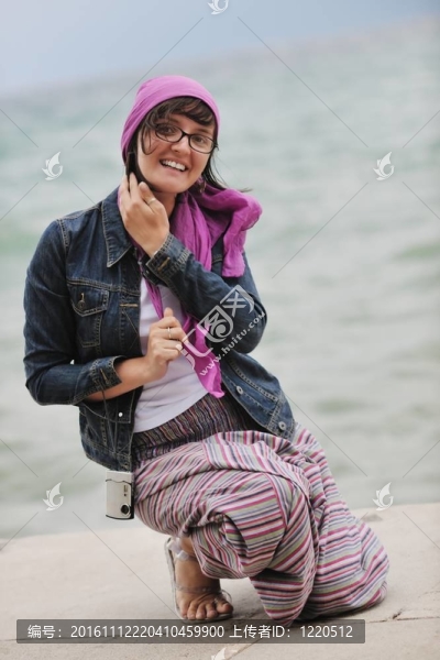 美麗的年輕女子在海灘與圍巾
