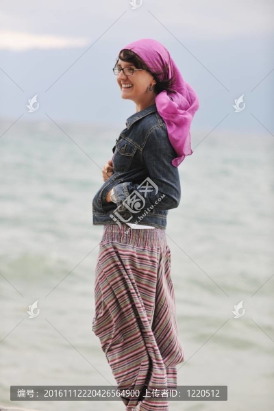 美麗的年輕女子在海灘與圍巾