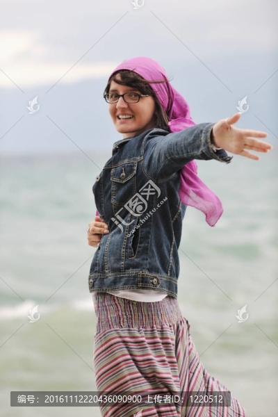 美麗的年輕女子在海灘與圍巾