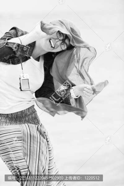 美麗的年輕女子在海灘與圍巾