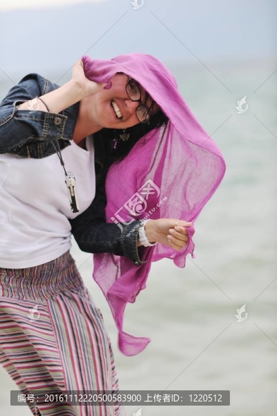美麗的年輕女子在海灘與圍巾