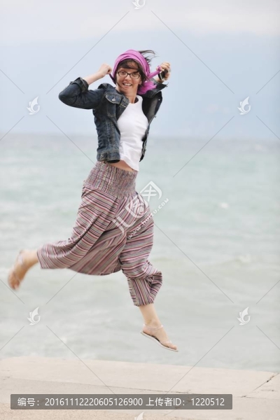 美麗的年輕女子在海灘與圍巾