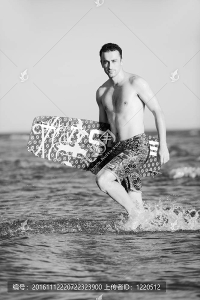 一個年輕人在海灘上的日落kitsurf肖像