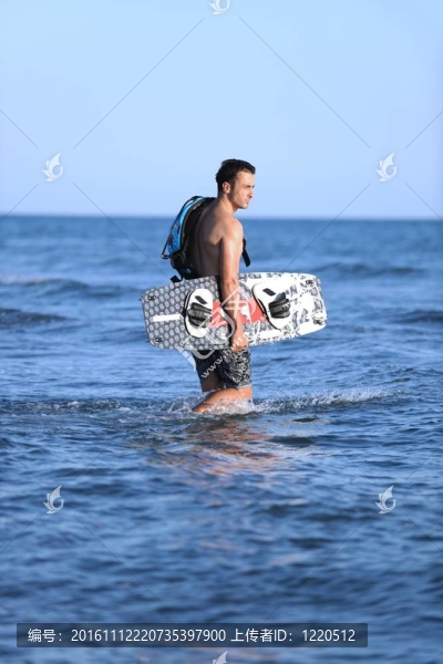 一個年輕人在海灘上的日落kitsurf肖像