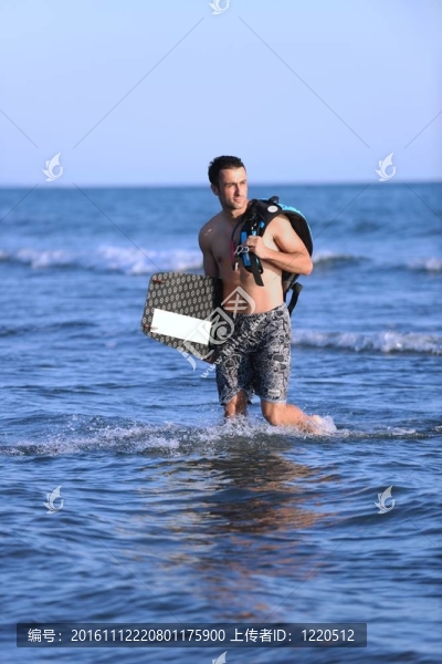 一個年輕人在海灘上的日落kitsurf肖像