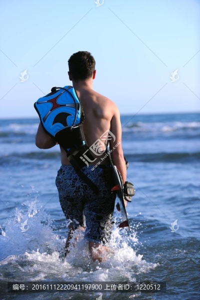 一個年輕人在海灘上的日落kitsurf肖像