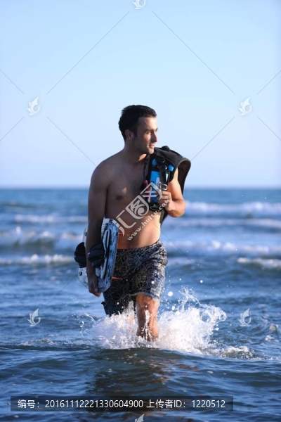 一個年輕人在海灘上的日落kitsurf肖像