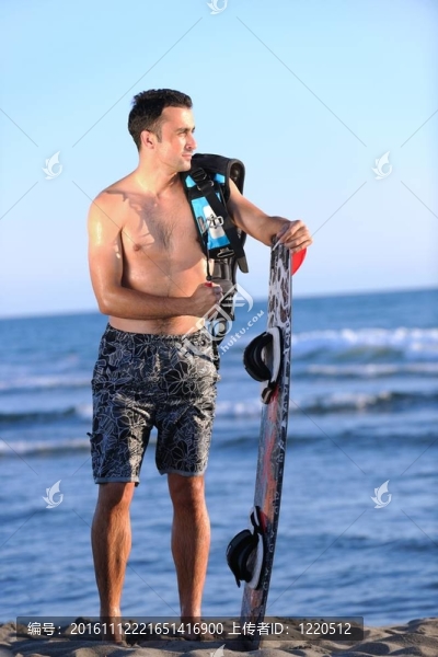 一個年輕人在海灘上的日落kitsurf肖像