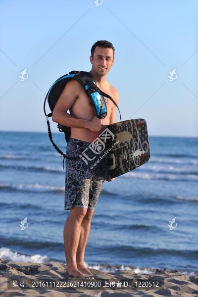 一個年輕人在海灘上的日落kitsurf肖像
