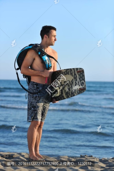 一個年輕人在海灘上的日落kitsurf肖像