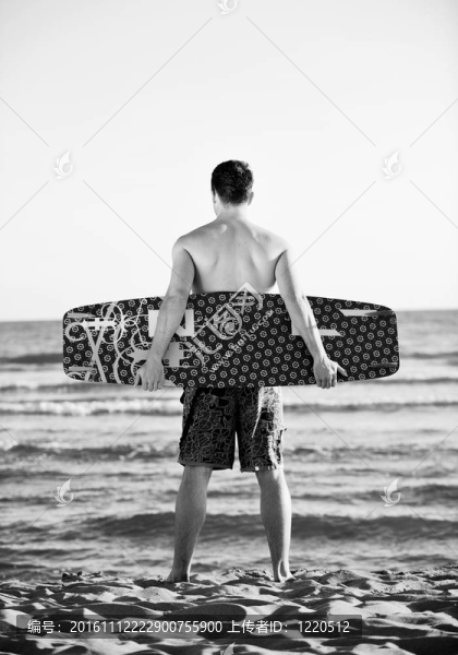 一個年輕人在海灘上的日落kitsurf肖像