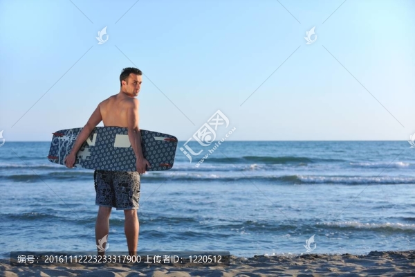 一個年輕人在海灘上的日落kitsurf肖像