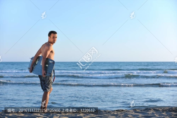 一個(gè)年輕人在海灘上的日落kitsurf肖像