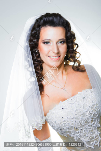 工作室肖像迷人的新娘穿著優(yōu)雅的婚紗與白色面紗