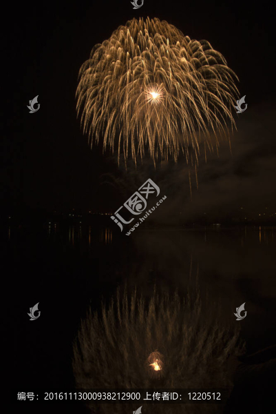 彩色煙花在黑色天空背景和水的倒影