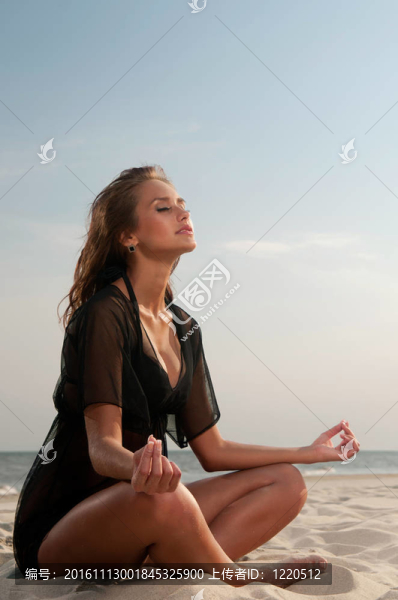 坐在海灘上的年輕女子
