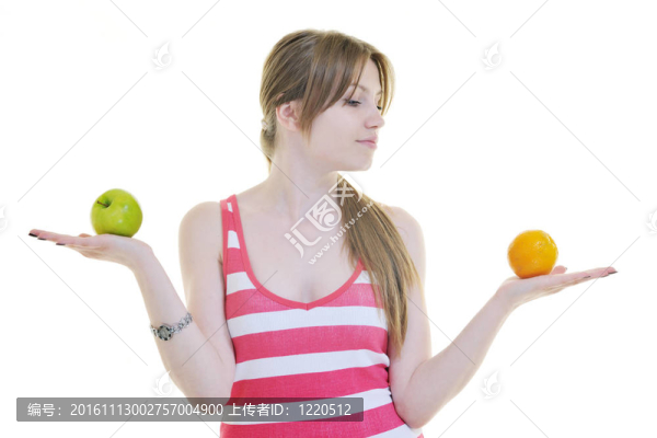 快樂的年輕女人吃白色的蘋果