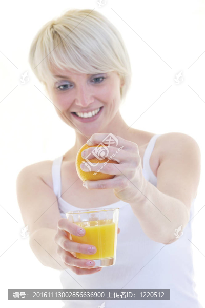 年輕的女人擠橙汁