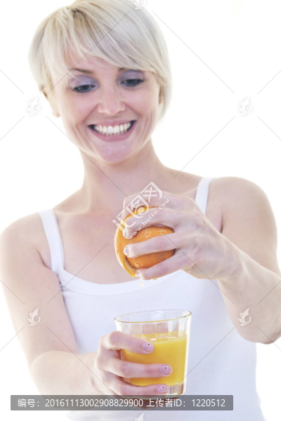 年輕的女人擠橙汁