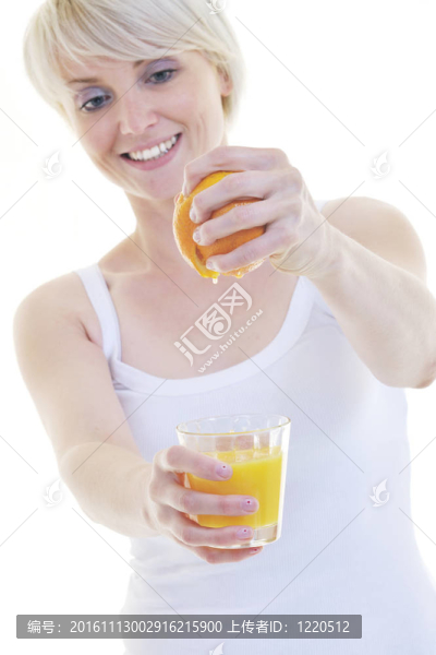 年輕的女人擠橙汁
