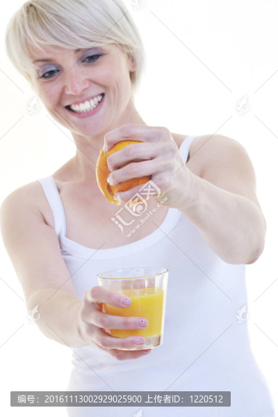年輕的女人擠橙汁