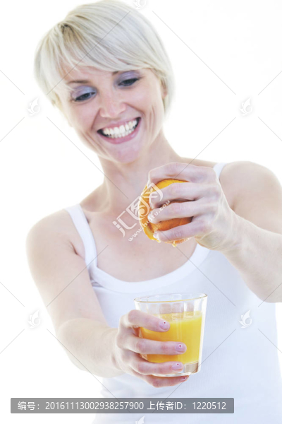 年輕的女人擠橙汁
