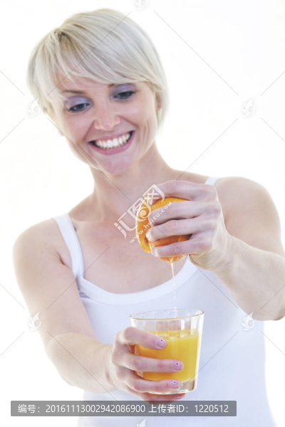年輕的女人擠橙汁