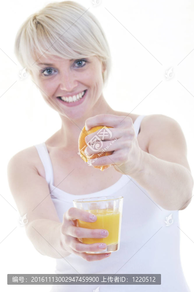 年輕的女人擠橙汁