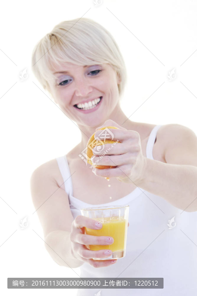 年輕的女人擠橙汁