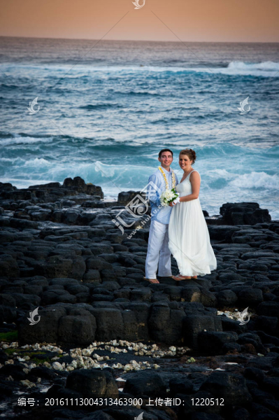 剛剛結(jié)婚。美麗的年輕夫婦在巖石海岸。
