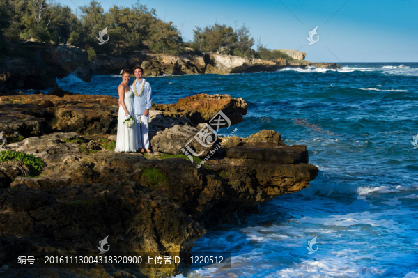 剛剛結(jié)婚。美麗的年輕夫婦在巖石海岸。