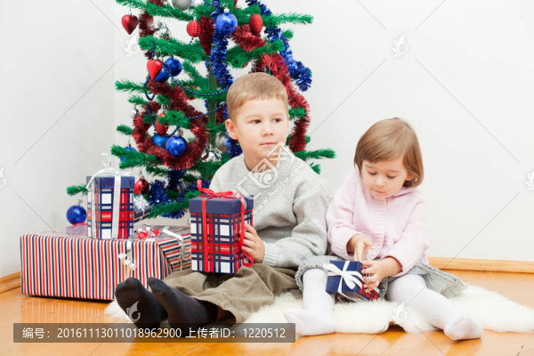 小孩子坐在一棵新年樹上