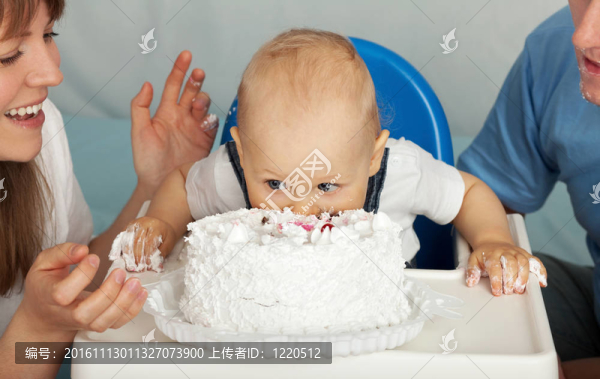 小孩吃蛋糕。家人慶祝兒子的第一個(gè)生日。