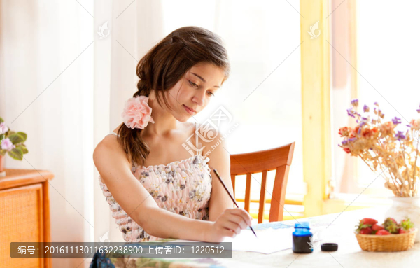 女孩在桌子上用鋼筆和墨水在夏天在室內(nèi)寫作