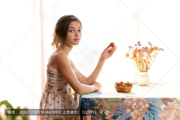 女孩吃草莓坐在桌子室內(nèi)夏天