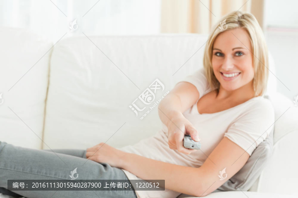 女人指著一個遙控器對著相機會心的一笑