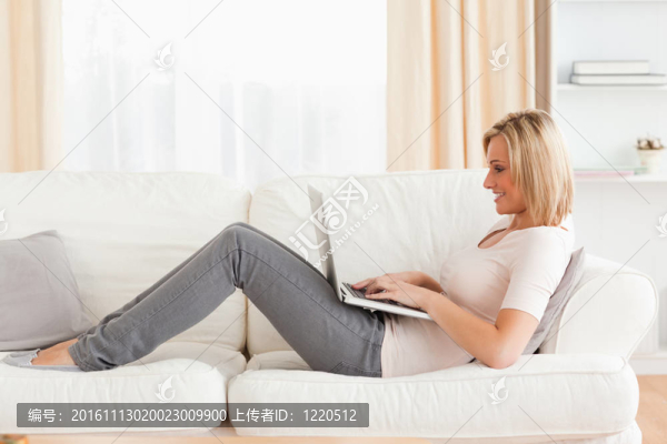 可愛(ài)的女人躺在沙發(fā)上用筆記本電腦-匯圖網(wǎng) www.fosd68.com 可愛(ài)的女人躺在沙發(fā)上用筆記本電腦