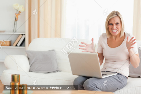 憤怒的金發(fā)女人使用筆記本電腦