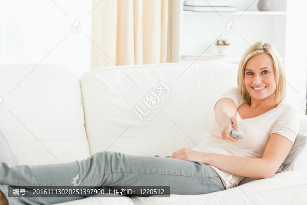 女人用遙控器帶著會心的微笑