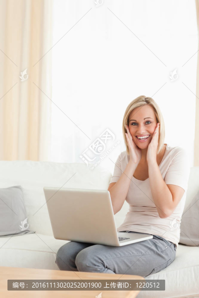 一個有著筆記本電腦的快樂女人的畫像