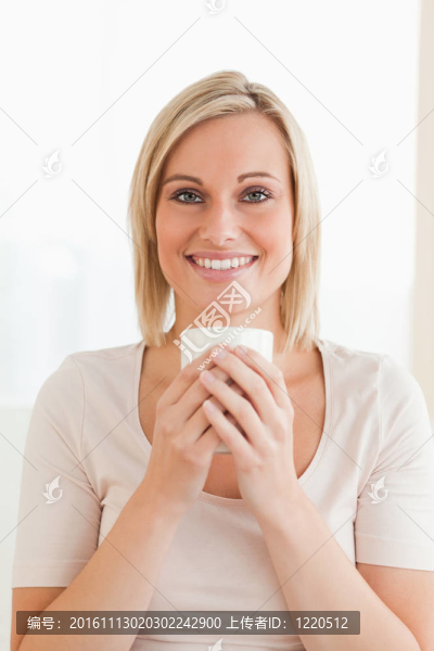 一個面帶微笑的女人拿著一杯咖啡的肖像