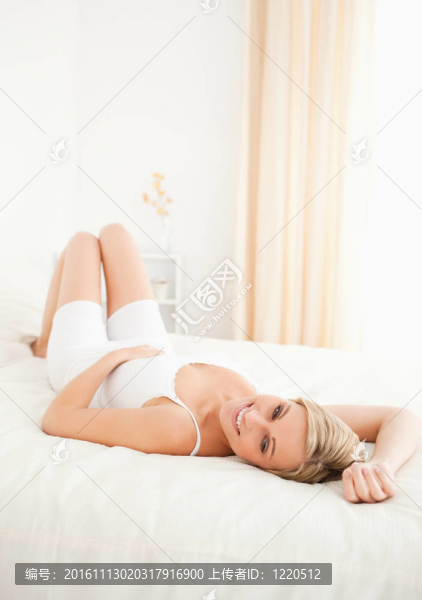 一個可愛的女人擺在她床上的肖像