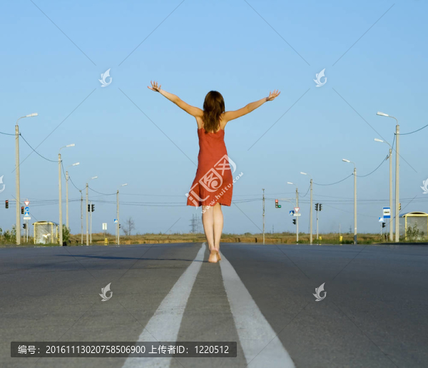 穿紅衣服的女孩赤腳走在空蕩蕩的路上