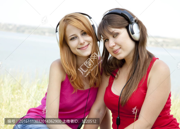 兩個(gè)十幾歲的女孩聽(tīng)MP3播放器