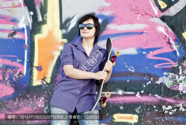 風(fēng)格的女孩滑板附近的涂鴉墻。