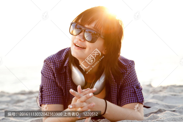 美麗的黑發(fā)女孩在沙灘的耳機。